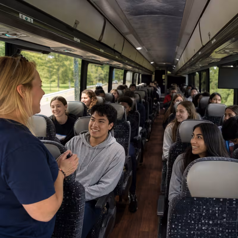 Group boarding a white charter bus for School Transportation transportation in Miami