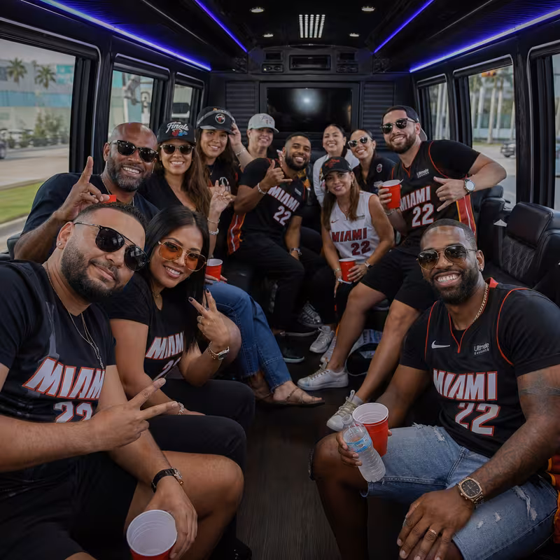 Group boarding a white charter bus for Sporting Event Transportation transportation in Miami