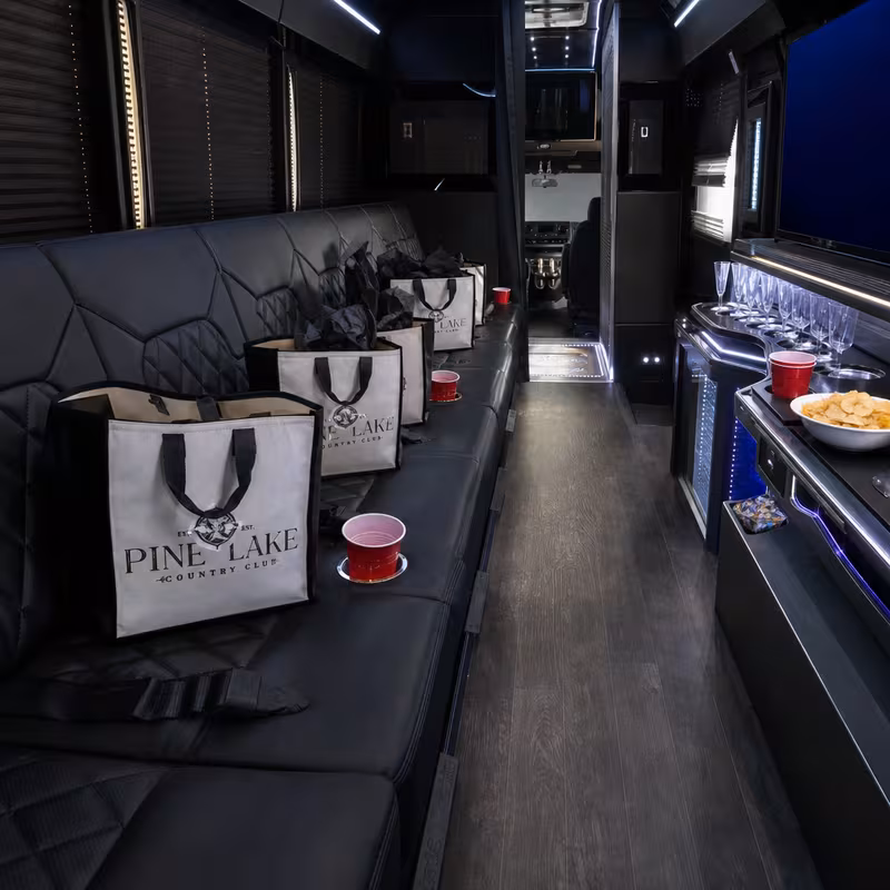 Party bus interior with wraparound leather seating and LED lighting in Miami